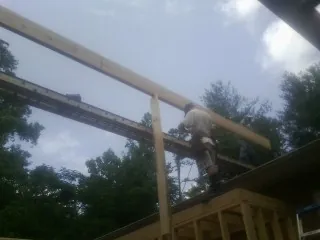 Carpenter setting a ridge beam over a new addition frame — Ice Dam Removal by Roofing Brothers in Bristol